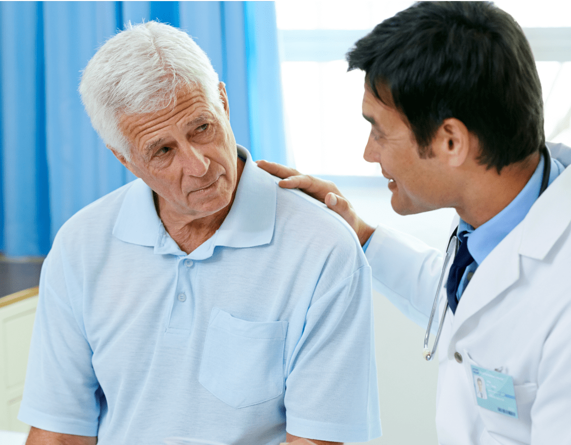A male physician putting his hand on the shoulder of an elderly male patient