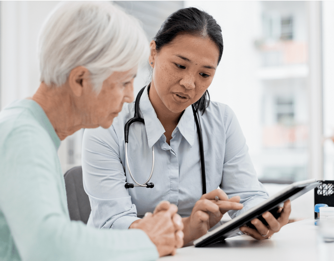 Img (13) A female clinician showing an elderly female patient her chart on a computer tablet
