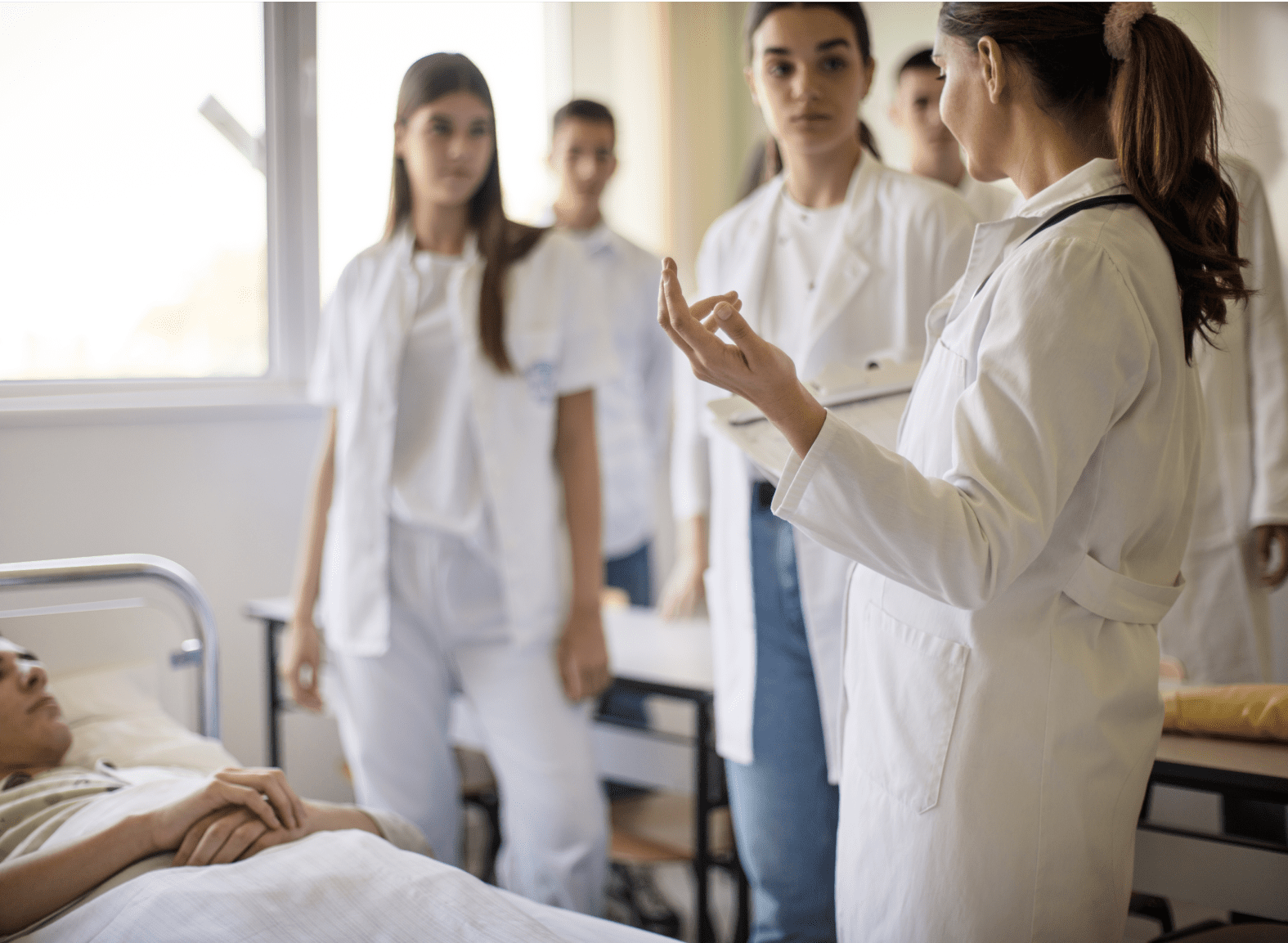A female physician instructing a diverse group of nursing students