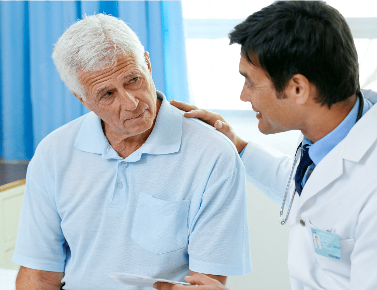 A male physician putting his hand on the shoulder of an elderly male patient
